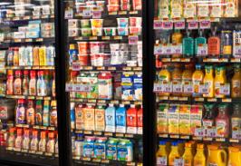 Refrigerated case stocked with yogurt, sour cream, milk, plant-based milks, and orange juice.