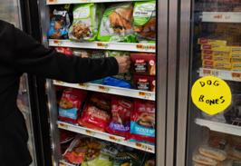 Restocking a freezer door full of frozen dinners and entrees