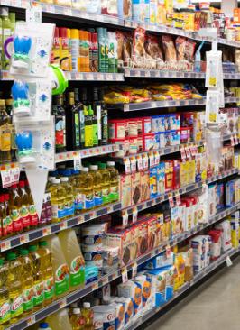 A grocery aisle stocked with oils, baking supplies, & spices.