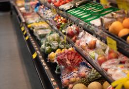 The produce section with melons, citrus, and fresh greens